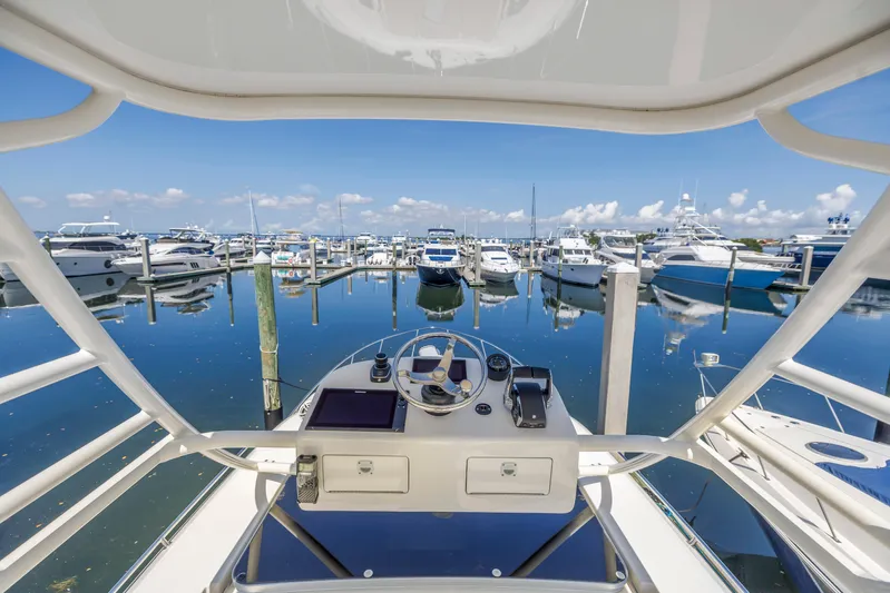  Yacht Photos Pics Boston Whaler 405 Conquest 2023 helm view at marina, surrounded by yachts and clear blue sky.