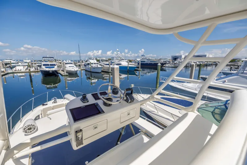  Yacht Photos Pics Boston Whaler 405 Conquest 2023 at marina, showcasing helm and serene waterfront view.