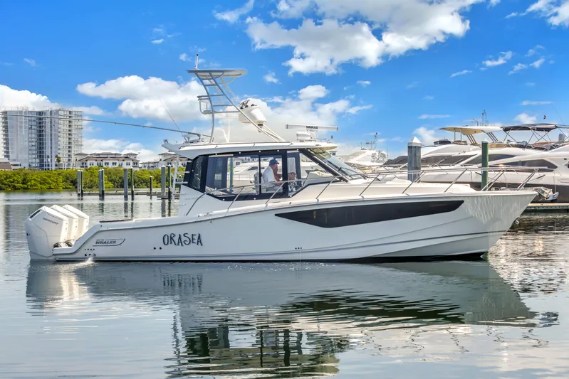  Yacht Photos Pics 2023 Boston Whaler 405 Conquest boat docked in marina under blue sky.