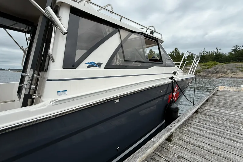  Yacht Photos Pics 2023 Cutwater C-248 Coupe docked by a wooden pier on a cloudy day.