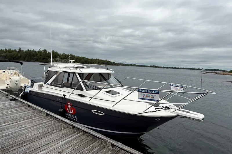  Yacht Photos Pics 2023 Cutwater C-248 Coupe boat for sale, docked by a scenic waterfront.