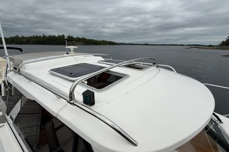  Yacht Photos Pics 2023 Cutwater C-248 Coupe boat on a calm lake under cloudy skies.