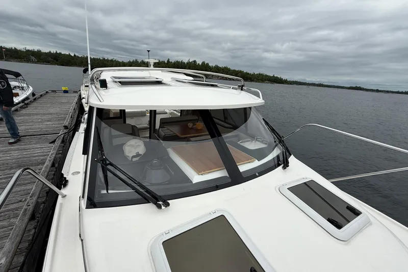  Yacht Photos Pics 2023 Cutwater C-248 Coupe docked by a wooden pier on a cloudy day.