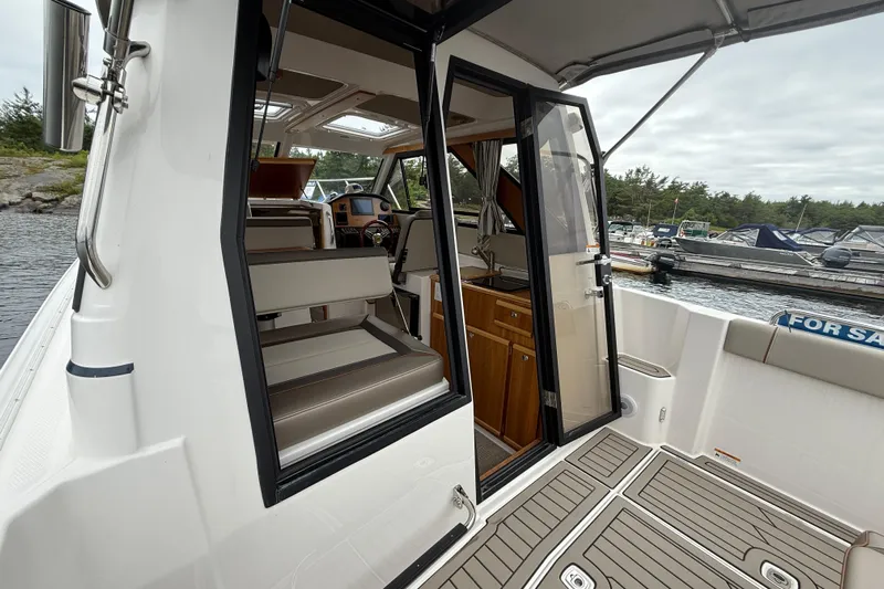  Yacht Photos Pics 2023 Cutwater C-248 Coupe interior view with seating and helm, docked by the water.