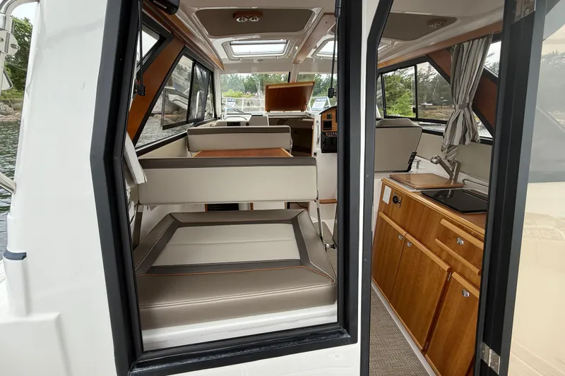  Yacht Photos Pics 2023 Cutwater C-248 Coupe interior with seating, kitchenette, and windows.