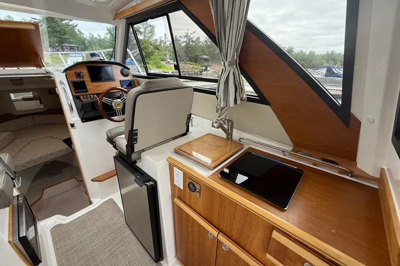  Yacht Photos Pics 2023 Cutwater C-248 Coupe interior with helm, kitchenette, and seating area.