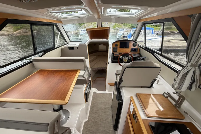  Yacht Photos Pics 2023 Cutwater C-248 Coupe interior with helm, seating, and dining area.