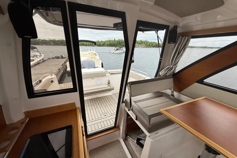  Yacht Photos Pics Interior view of 2023 Cutwater C-248 Coupe, featuring seating and table, overlooking a serene lake.