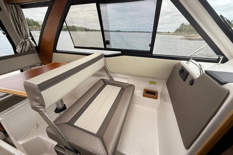  Yacht Photos Pics 2023 Cutwater C-248 Coupe interior with seating and table, overlooking serene water view.