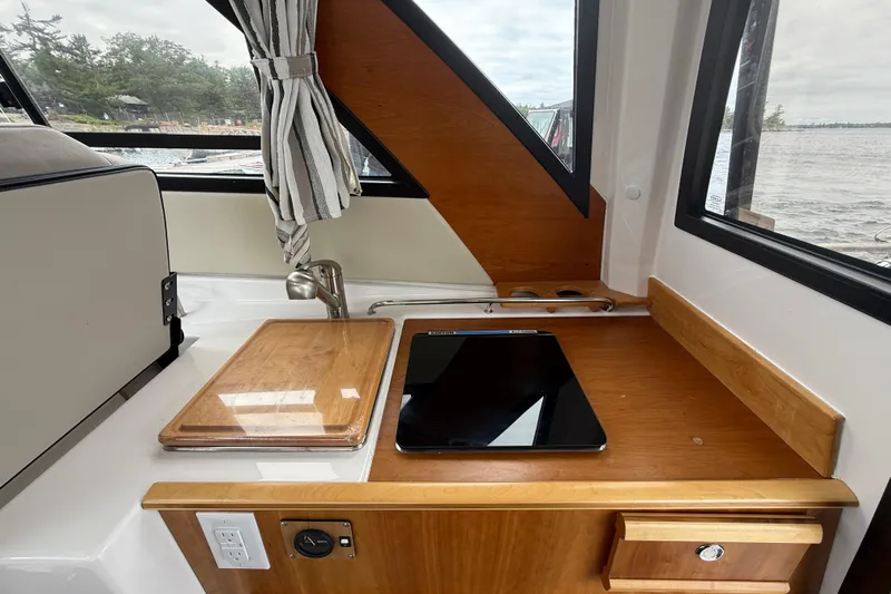  Yacht Photos Pics 2023 Cutwater C-248 Coupe interior with wooden countertop and sink, overlooking water.