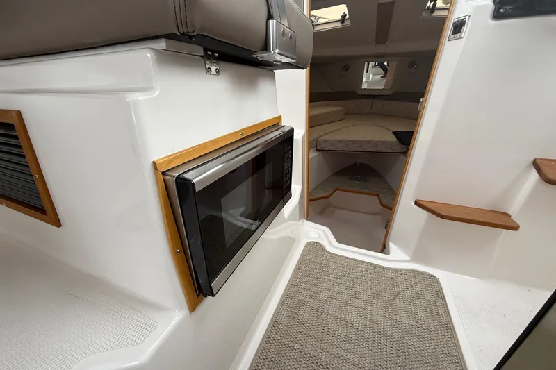 Yacht Photos Pics 2023 Cutwater C-248 Coupe interior with microwave, steps, and cozy cabin area.