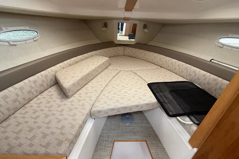  Yacht Photos Pics 2023 Cutwater C-248 Coupe interior cabin with beige seating and porthole windows.