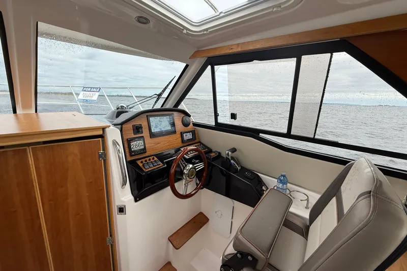  Yacht Photos Pics 2023 Cutwater C-248 Coupe interior with steering wheel, navigation system, and ocean view.