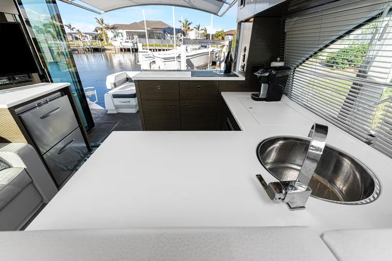 Lil' Darlin' Yacht Photos Pics 2018 Cruisers Yachts 50 Cantius kitchen with modern sink, countertop, and marina view.