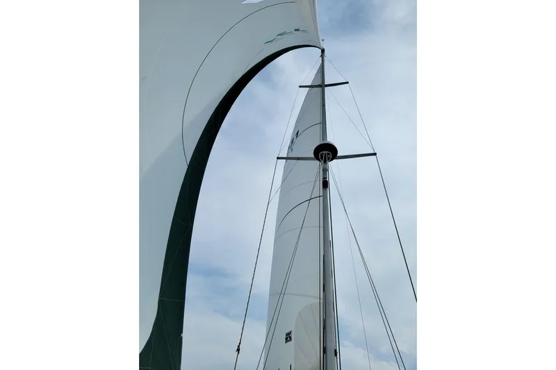 Alize Yacht Photos Pics Sailboat mast and sails of a 1999 Catalina 400 against a cloudy sky.