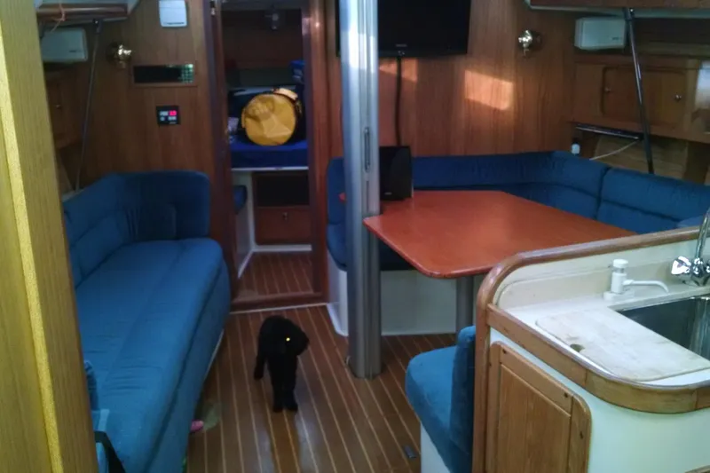 Alize Yacht Photos Pics Interior of a 1999 Catalina 400 sailboat with blue seating and wooden finishes.