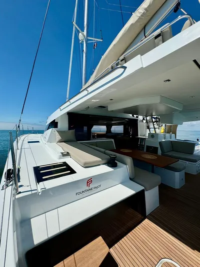  Yacht Photos Pics 2024 Fountaine Pajot Catamaran Elba 45, spacious deck, luxurious seating, clear blue sky.