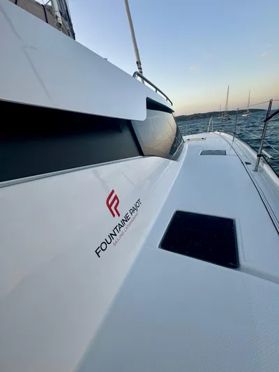  Yacht Photos Pics 2024 Fountaine Pajot Catamaran Elba 45 sailing on open water at sunset.