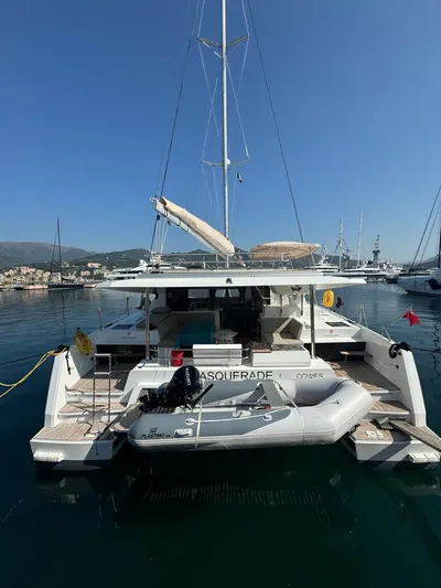  Yacht Photos Pics 2024 Fountaine Pajot Catamaran Elba 45 docked with inflatable boat, clear sky background.