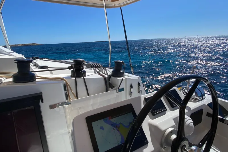  Yacht Photos Pics 2024 Fountaine Pajot Catamaran Elba 45 sailing on open sea, sunny day, clear blue water.