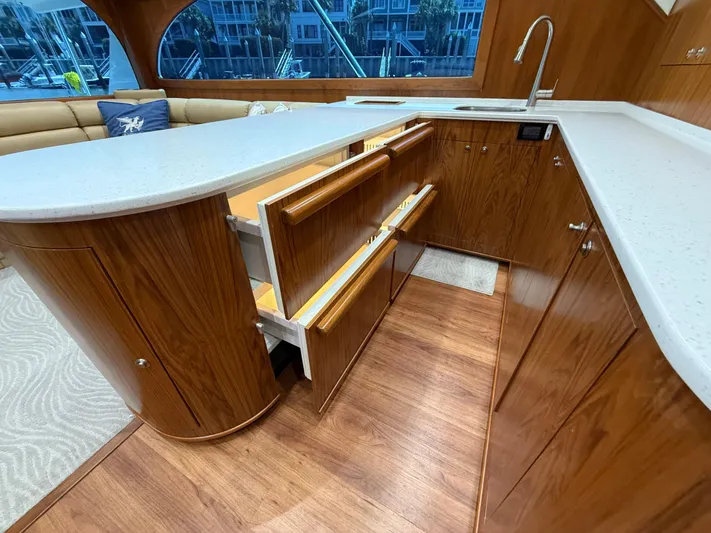 Gryphon Yacht Photos Pics Luxurious yacht kitchen with wooden cabinetry, open drawers, and modern fixtures on a Custom Carolina Ritchie Howell.