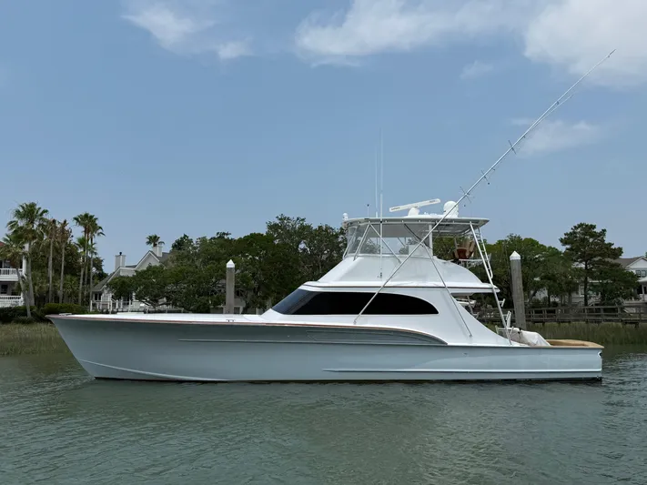 Gryphon Yacht Photos Pics Custom Carolina Ritchie Howell 2002 yacht docked on calm water, surrounded by trees and houses.