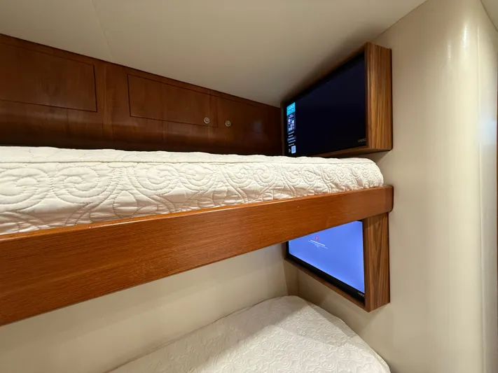 Gryphon Yacht Photos Pics Bunk beds with wooden frames and built-in TVs on a 2002 Custom Carolina Ritchie Howell boat.