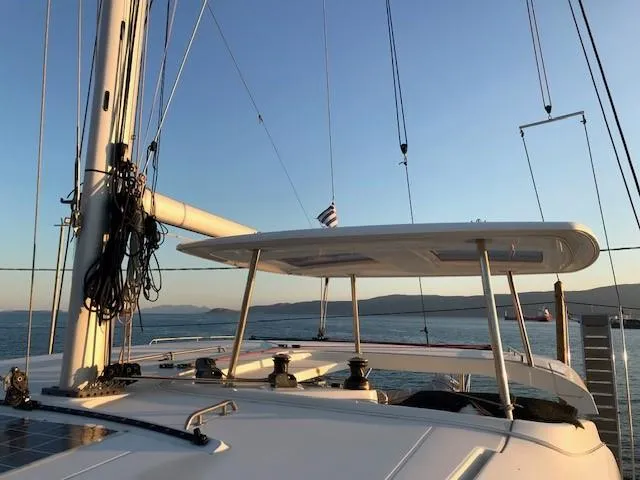 Petalida Yacht Photos Pics 2017 Lagoon 42 catamaran sailing at sunset with clear skies and calm waters.