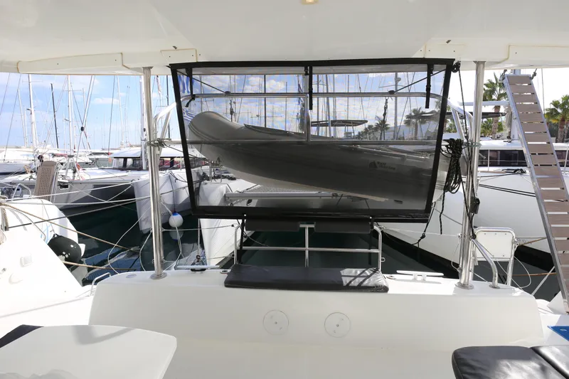 Petalida Yacht Photos Pics 2017 Lagoon 42 catamaran with dinghy, docked at marina, showcasing spacious deck area.