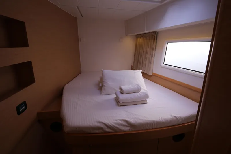 Petalida Yacht Photos Pics Cozy bedroom in 2017 Lagoon 42 yacht with window view and neatly arranged bedding.