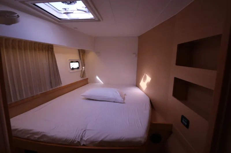 Petalida Yacht Photos Pics Cozy cabin interior of 2017 Lagoon 42 catamaran with bed and porthole.