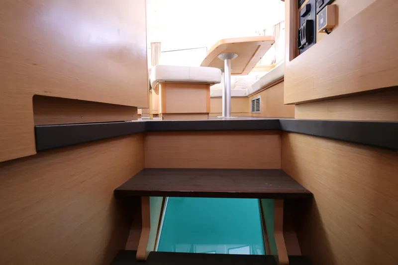 Petalida Yacht Photos Pics Interior of 2017 Lagoon 42 catamaran with wooden steps and seating area.