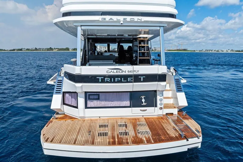 Triple T Yacht Photos Pics 2022 Galeon 640 Fly yacht on open water, rear view with wooden deck.