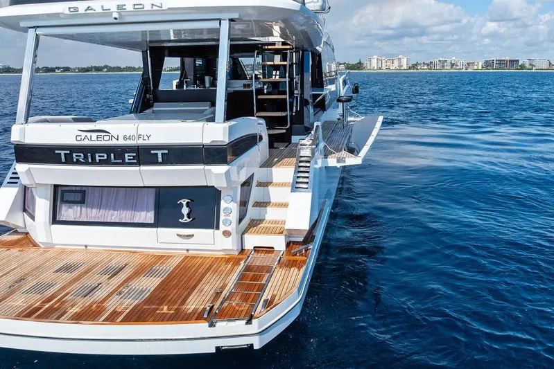 Triple T Yacht Photos Pics 2022 Galeon 640 Fly yacht on water, rear view with open deck and city skyline.