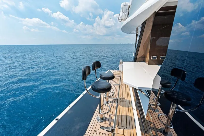 Triple T Yacht Photos Pics Luxurious 2022 Galeon 640 Fly yacht deck with bar stools overlooking the ocean.