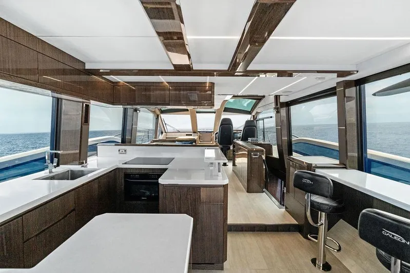 Triple T Yacht Photos Pics Luxurious interior of 2022 Galeon 640 Fly yacht with modern kitchen and ocean view.