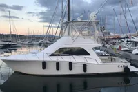 2007 Cabo 43 FB yacht docked at marina during sunset, surrounded by sailboats.