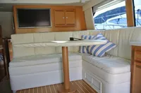 Luxurious interior of 2007 Cabo 43 FB yacht with plush seating and striped cushions.