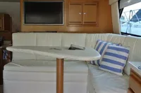 Interior of 2007 Cabo 43 FB yacht with white seating and striped cushions.