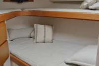 2007 Cabo 43 FB cabin with bunk beds, wooden storage, and a small TV.