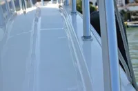 2007 Cabo 43 FB yacht deck with railing, docked near waterfront buildings.
