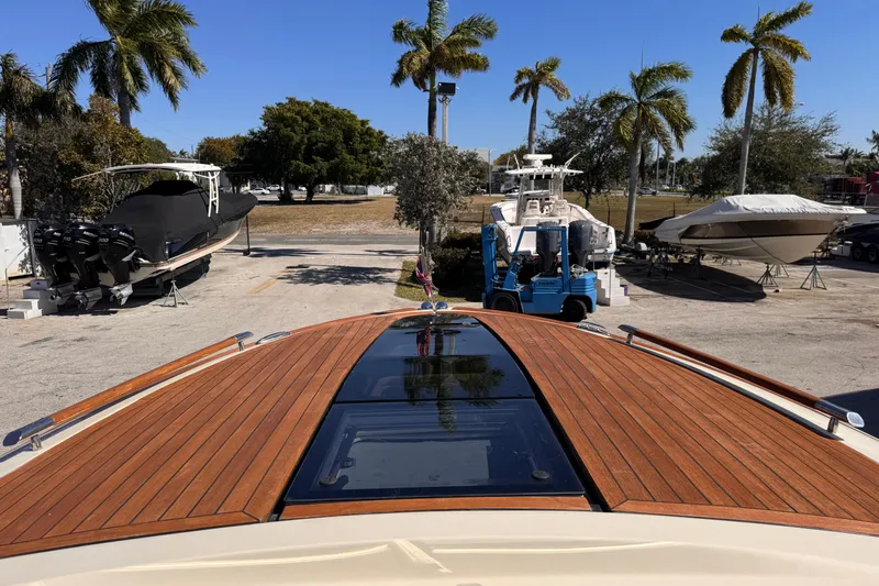  Yacht Photos Pics 2019 Chris-Craft Corsair 30 boat with wooden deck, parked near palm trees.