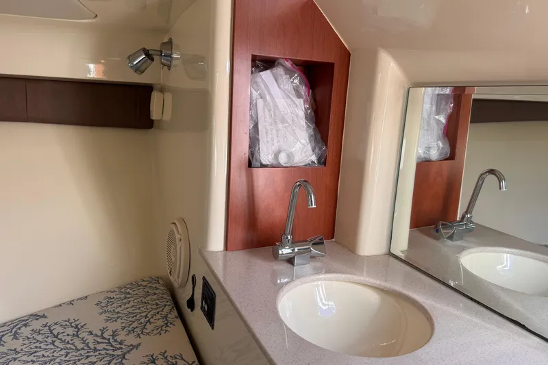  Yacht Photos Pics 2019 Chris-Craft Corsair 30 interior with sink, mirror, and storage compartment.