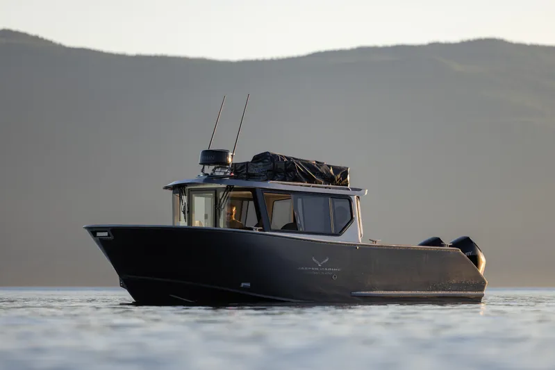 Jasper Marine Defender 22 Yacht Photos Pics 2025 Jasper Marine Defender 22 - Storm Bow boat on calm water with mountainous backdrop.