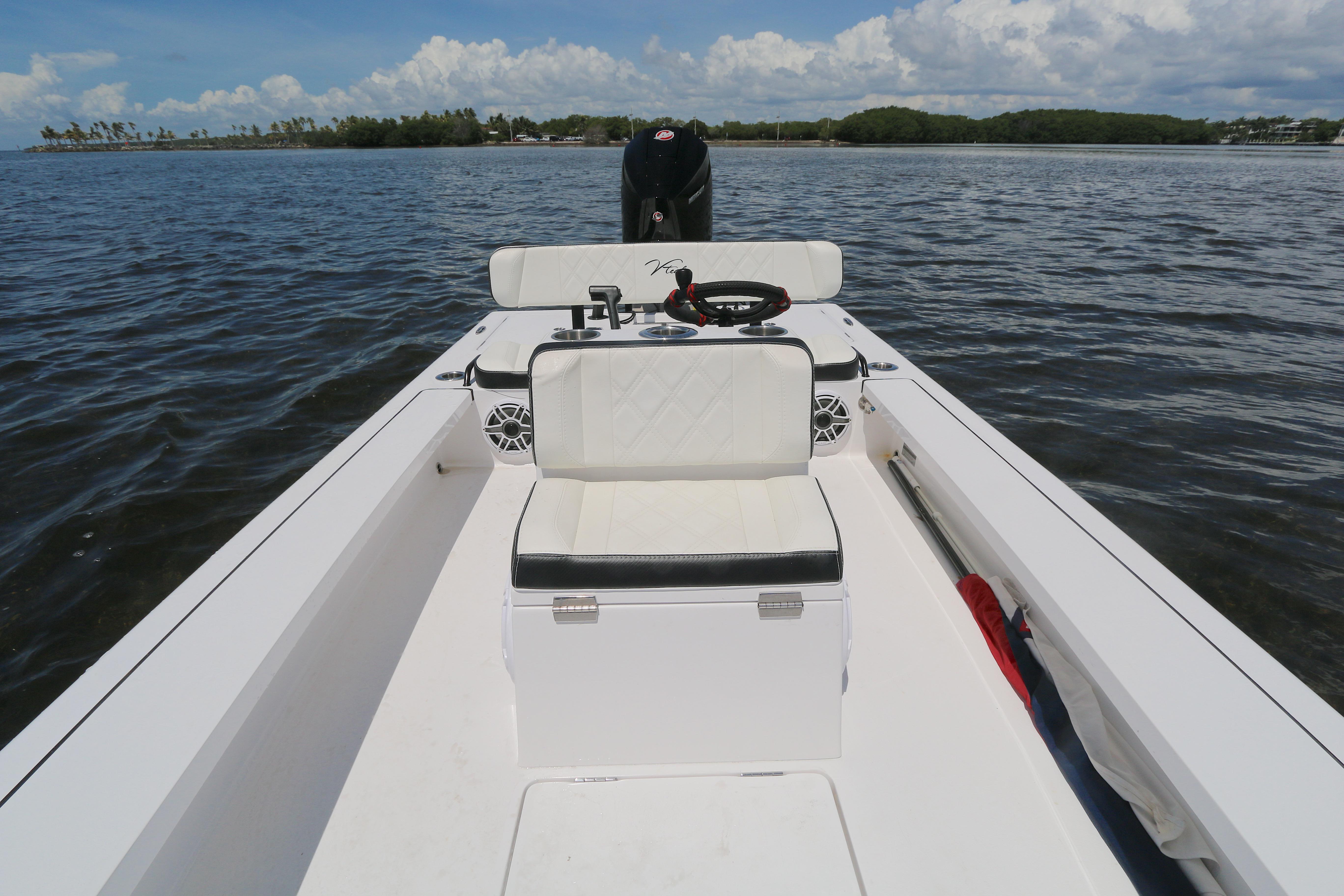 2024 Vtech 18 boat interior on calm water, featuring seating and steering console.