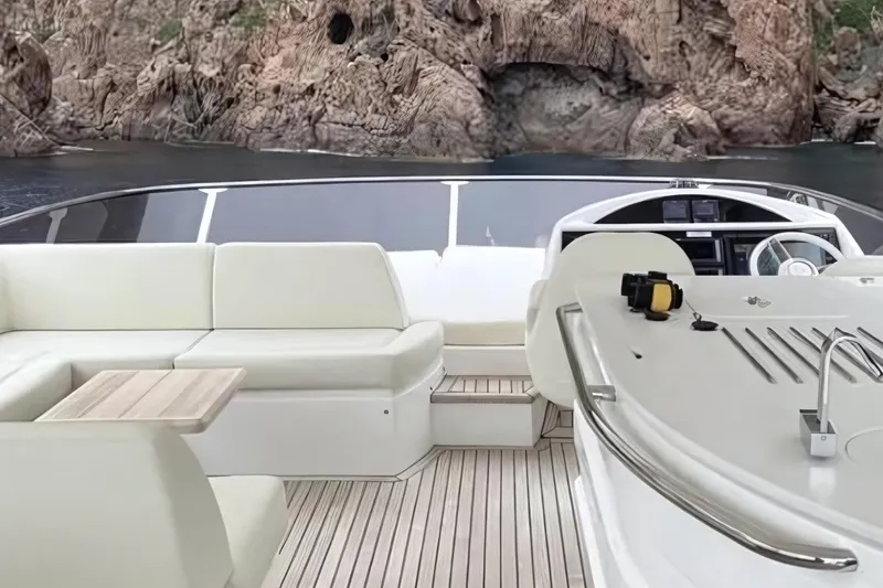 Sarahlisa Yacht Photos Pics Luxurious Sunseeker 75 yacht interior with elegant seating and scenic rocky backdrop.