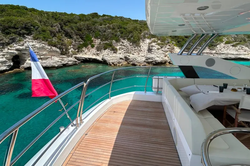 Sarahlisa Yacht Photos Pics Luxurious 2015 Sunseeker 75 yacht with scenic coastal view and French flag.