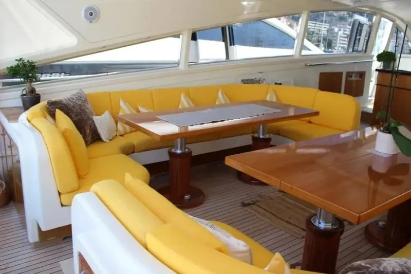  Yacht Photos Pics Luxurious interior of 2000 Cantieri dell'Arno Leopard 27 yacht with yellow seating and wooden tables.
