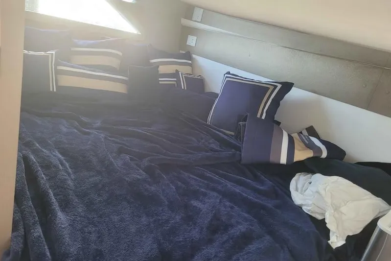  Yacht Photos Pics Luxurious bed with navy and striped pillows in 2024 Hanover 387 interior.