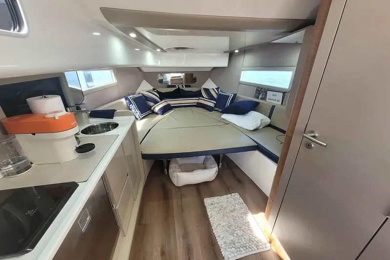  Yacht Photos Pics Luxurious interior of 2024 Hanover 387 yacht with cozy bed and modern kitchenette.